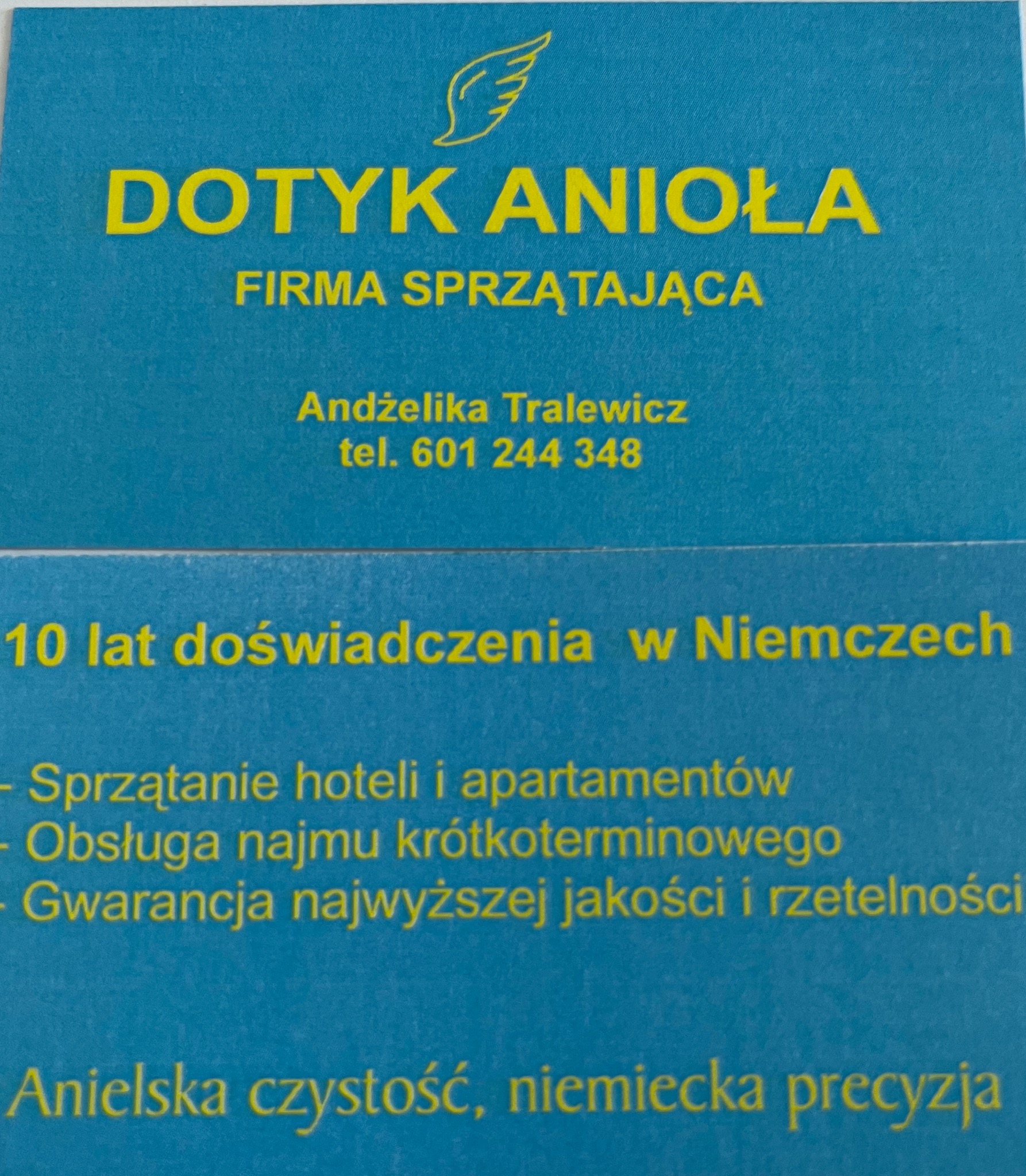 Wizytówka firmy sprzątającej 'Dotyk Anioła' z ofertą sprzątania hoteli i apartamentów, obsługi najmu krótkoterminowego oraz gwarancją jakości. Żółty tekst na niebieskim tle.