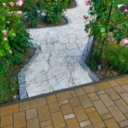 BRUK-OSZ - Ścieżka z nieregularnej kostki kamiennej, obrzeża z kostki granitowej, rabaty z różami. Układanie kostki brukowej i granitowej w ogrodzie.