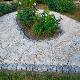 BRUK-OSZ - Ścieżka z nieregularnych płyt kamiennych, obrzeża z kostki granitowej, wysypana drobnym żwirem, otoczona zielenią. Elementy ogrodu w naturalnym stylu.