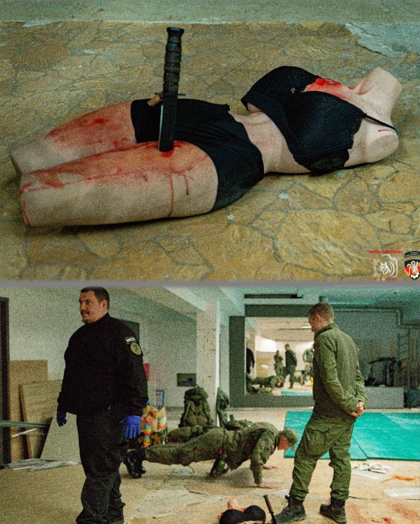 Szkolenie z pierwszej pomocy: manekin z wbitym nożem, imitacja ran. W tle żołnierze ćwiczą, jeden robi pompki. Instruktorzy nadzorują. Realistyczny scenariusz.