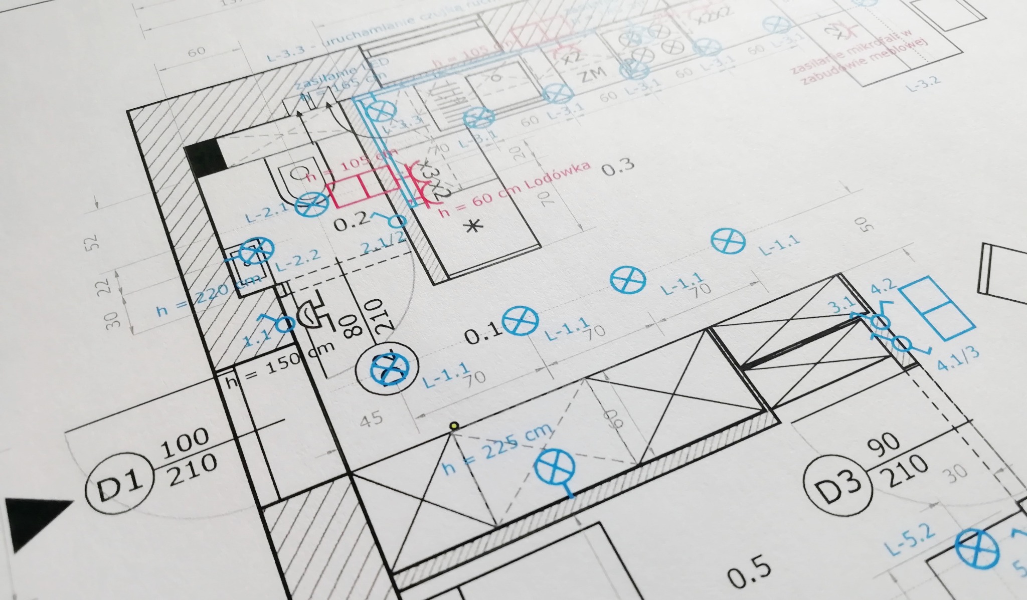 Fragment planu architektonicznego z wymiarami i oznaczeniami instalacji, widok z góry, czarno-biały z niebieskimi akcentami, detale techniczne.