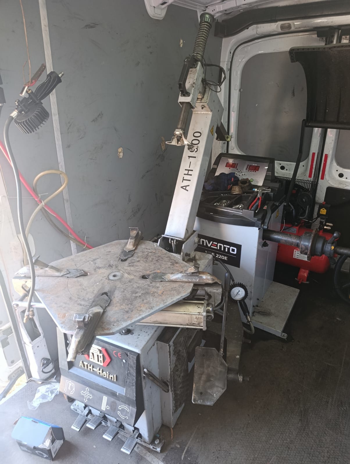 Wnętrze mobilnego warsztatu wulkanizacyjnego: wyważarka do kół ATH-Heinl i Invento 220E, narzędzia, oświetlenie robocze, widok z wnętrza furgonetki.