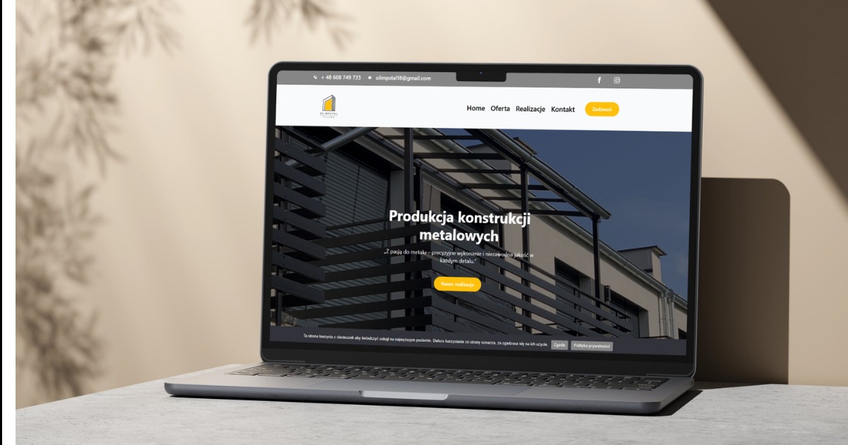 Laptop prezentuje stronę internetową firmy Olimpstal z konstrukcjami metalowymi. Widoczny fragment strony z ofertą i realizacjami. Minimalistyczny design, stonowana kolorystyka.