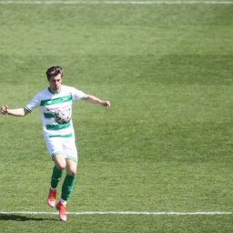 Maciej Stanowski - Młody mężczyzna w sportowym stroju z piłką na boisku w Łodzi. Dynamiczne ujęcie, trening piłkarski na tle zielonej trawy i białych linii.