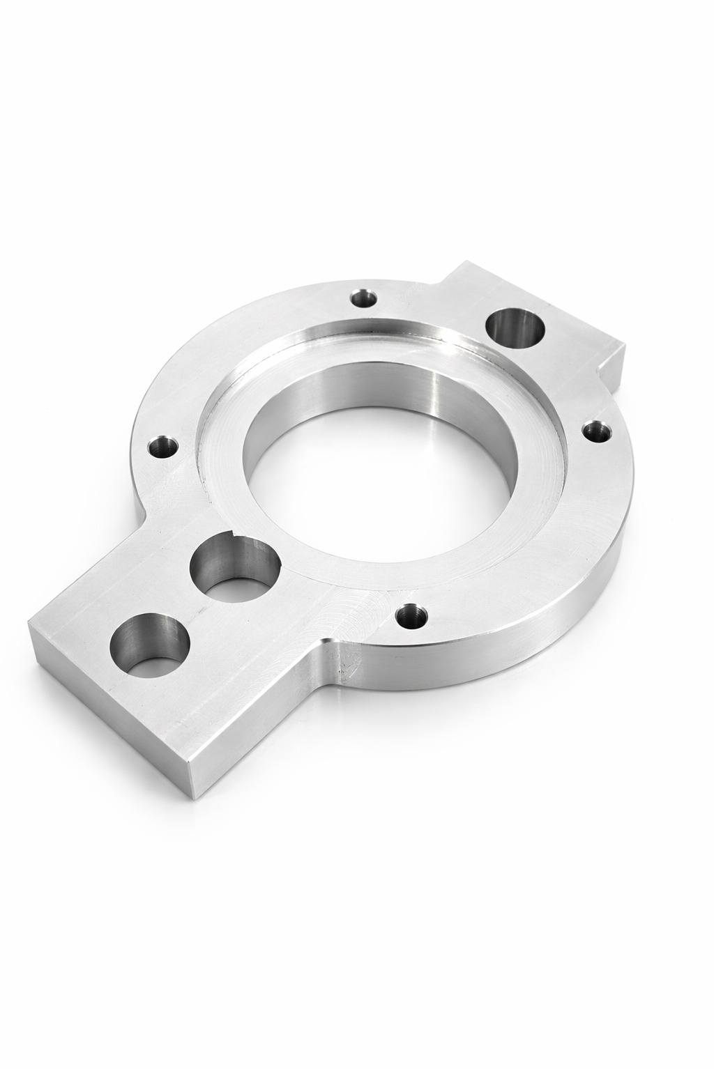 Precyzyjnie wykonany, srebrny element metalowy z otworami o różnych średnicach, leżący na białym tle. Widoczne ślady obróbki.