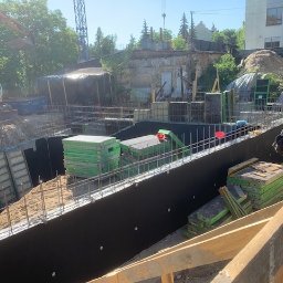 SP WARSZAWA SPÓŁKA Z OGRANICZONĄ ODPOWIEDZIALNOŚCIĄ - Wykonanie wykopu pod fundamenty z użyciem szalunków i zbrojenia. Na budowie widoczny jest także ciężki sprzęt budowlany.
