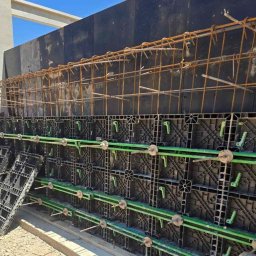 PLASPANEL Ltd - Szczegółowe ujęcie szalunku zbrojeniowego z widocznymi elementami konstrukcyjnymi i stalowymi prętami, przygotowanego do zalewania betonem.