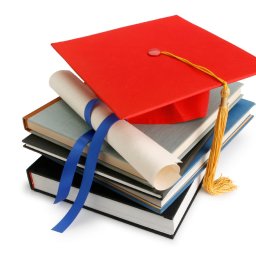 BIG Coaching Barbara Gałuszka - Czerwony biret na stosie książek z dyplomem przewiązanym niebieską wstążką, symbolizujący ukończenie kursu lub szkolenia zawodowego.