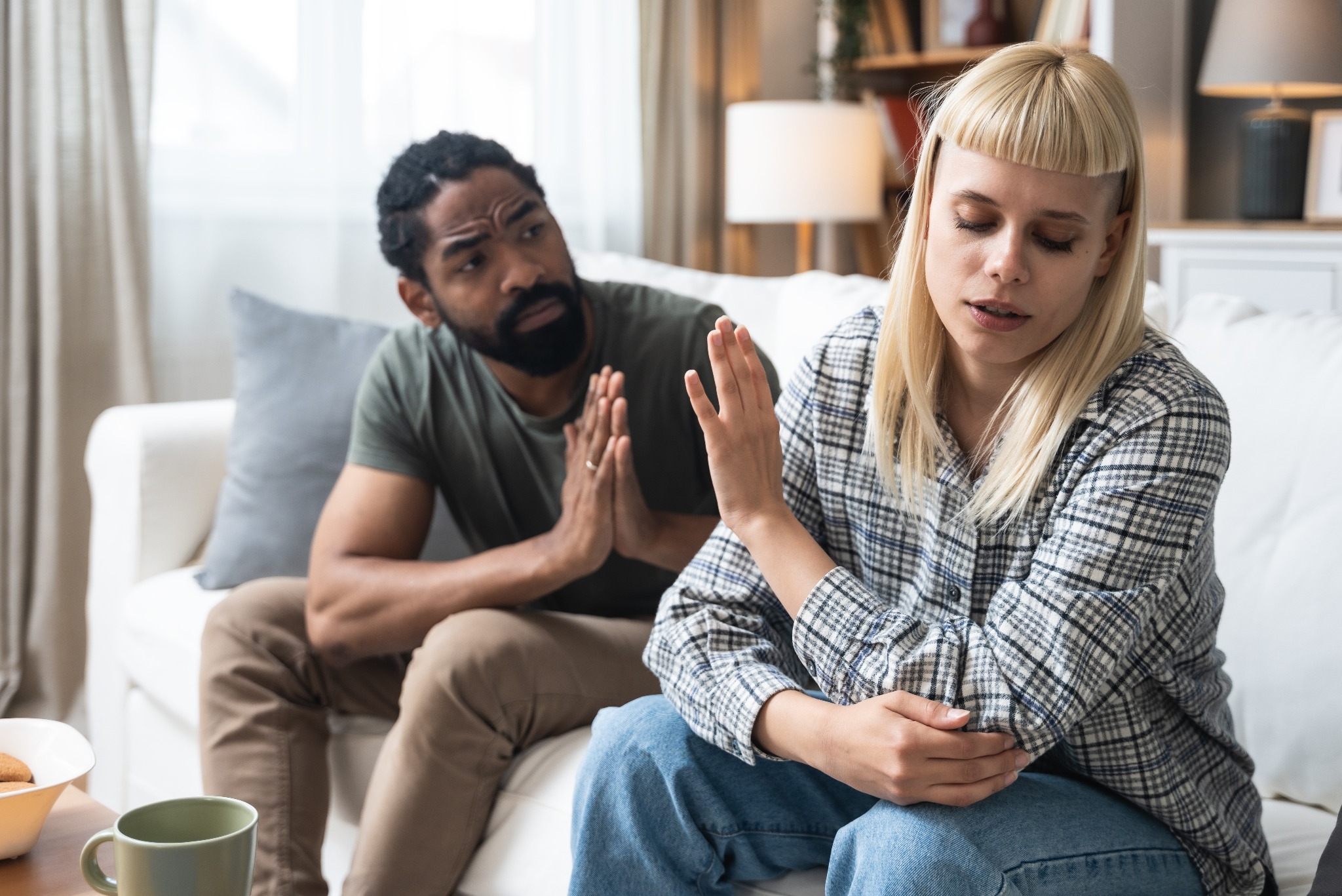 Para siedzi na kanapie, kobieta odmawia, mężczyzna błaga. Emocje, konflikt, potencjalny rozwód. Domowe tło, naturalne światło.