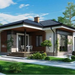 FIOŁBUD GRAŻYNA FIJAŁKOWSKA - Nowoczesny dom parterowy z elementami kamienia i drewna, czarnym dachem i zadbanym ogrodem. Widoczne schody wejściowe i taras z meblami.