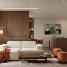 Martyna Koperska Wnętrza - Nowoczesny salon z narożną sofą w odcieniach bieli, drewnianą ścianą i wyspą kuchenną z blatem z zielonego marmuru. Całość dopełniają pomarańczowe pufy i abstrakcyjny obraz.