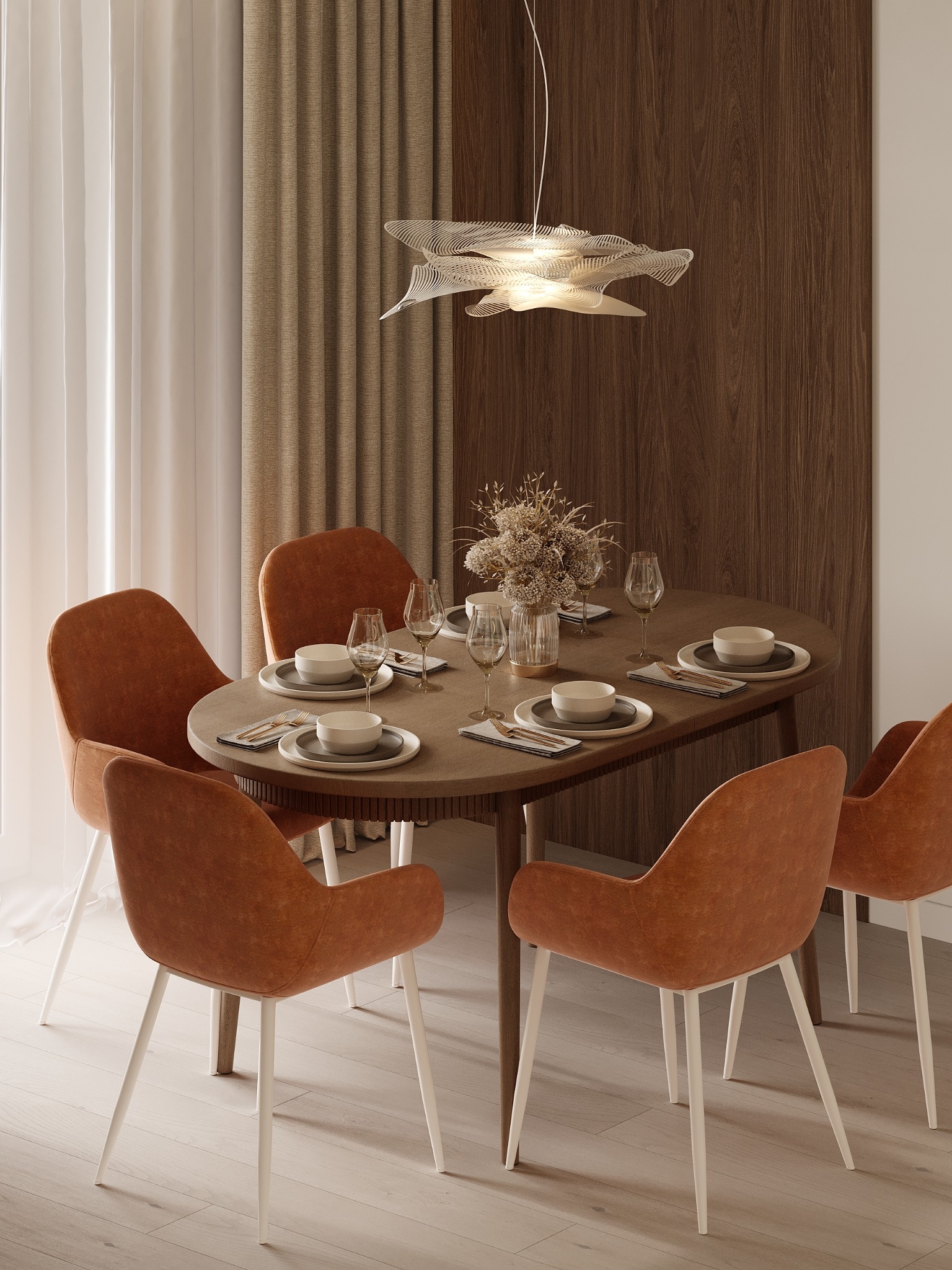Jadalnia w ciepłych barwach: okrągły stół z nakryciem, pomarańczowe krzesła na białych nogach, designerska lampa i drewniana ściana w tle.