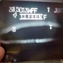 NDTEST - Radiogram spoiny z widocznymi numerami seryjnymi i oznaczeniami, trzymany w dłoni. Kontrola jakości spoin.