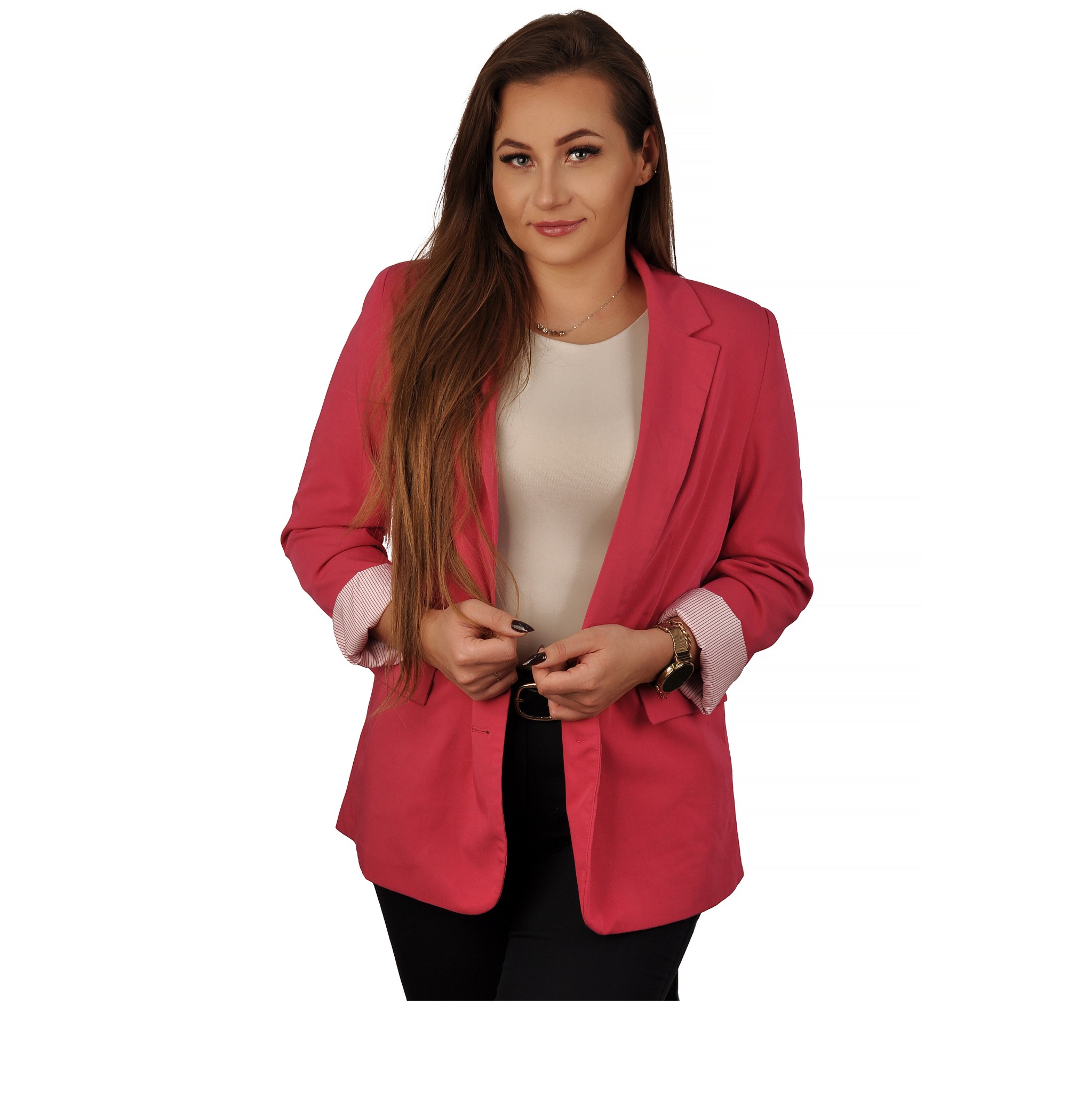 Uśmiechnięta kobieta w różowej marynarce, białej bluzce i czarnych spodniach, pozująca na białym tle. Widoczny zegarek i delikatny naszyjnik.