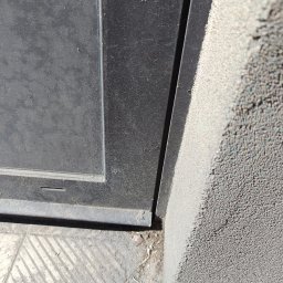 Jaroslav Dvoran - Mycie Okien Bydgoszcz - Brudne okno z ramą, zanieczyszczony parapet i chodnik przed budynkiem. Widoczne ślady kurzu i pyłu na powierzchniach.