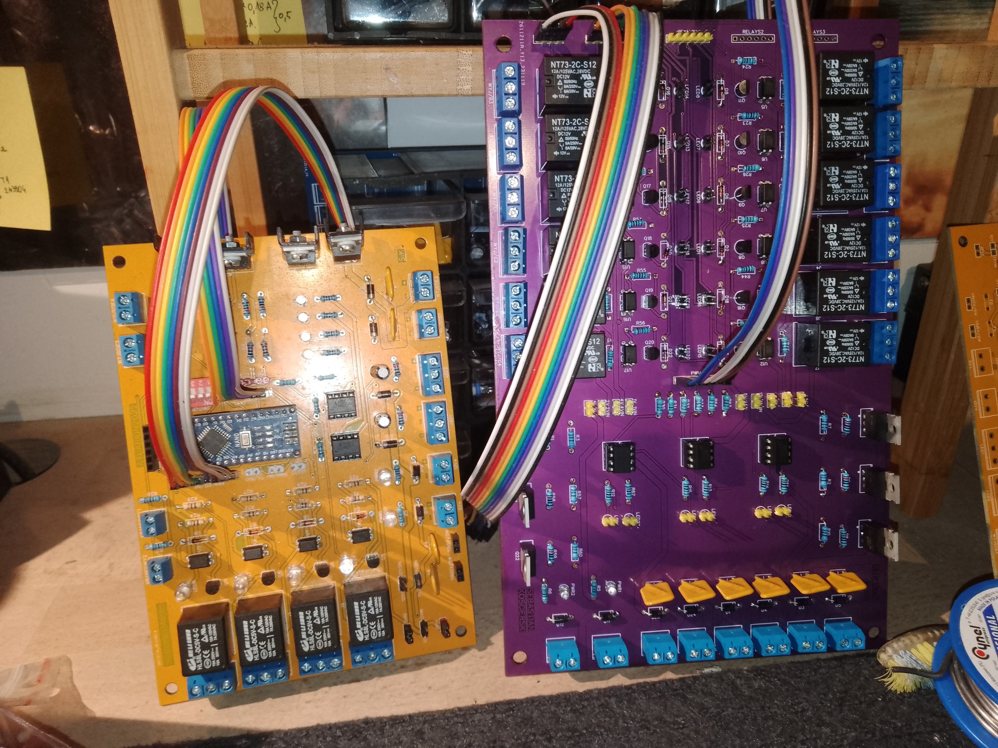 Dwie płyty PCB z elementami elektronicznymi i przewodami w Bydgoszczy. Żółta i fioletowa, z widocznymi rezystorami i złączami. Precyzyjna elektronika.