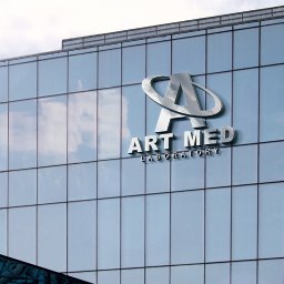 MaTaWi Marek Wojakowski - Elewacja budynku z logo 'ART MED Laboratory' w srebrnej kolorystyce, widoczne odbicie chmur w szklanej fasadzie. Ujęcie z dołu, podkreślające nowoczesny charakter.