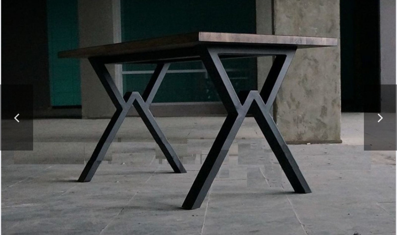 Stół z drewnianym blatem i metalową podstawą w kształcie litery X, spawana konstrukcja, surowy industrialny styl, szara kolorystyka tła.