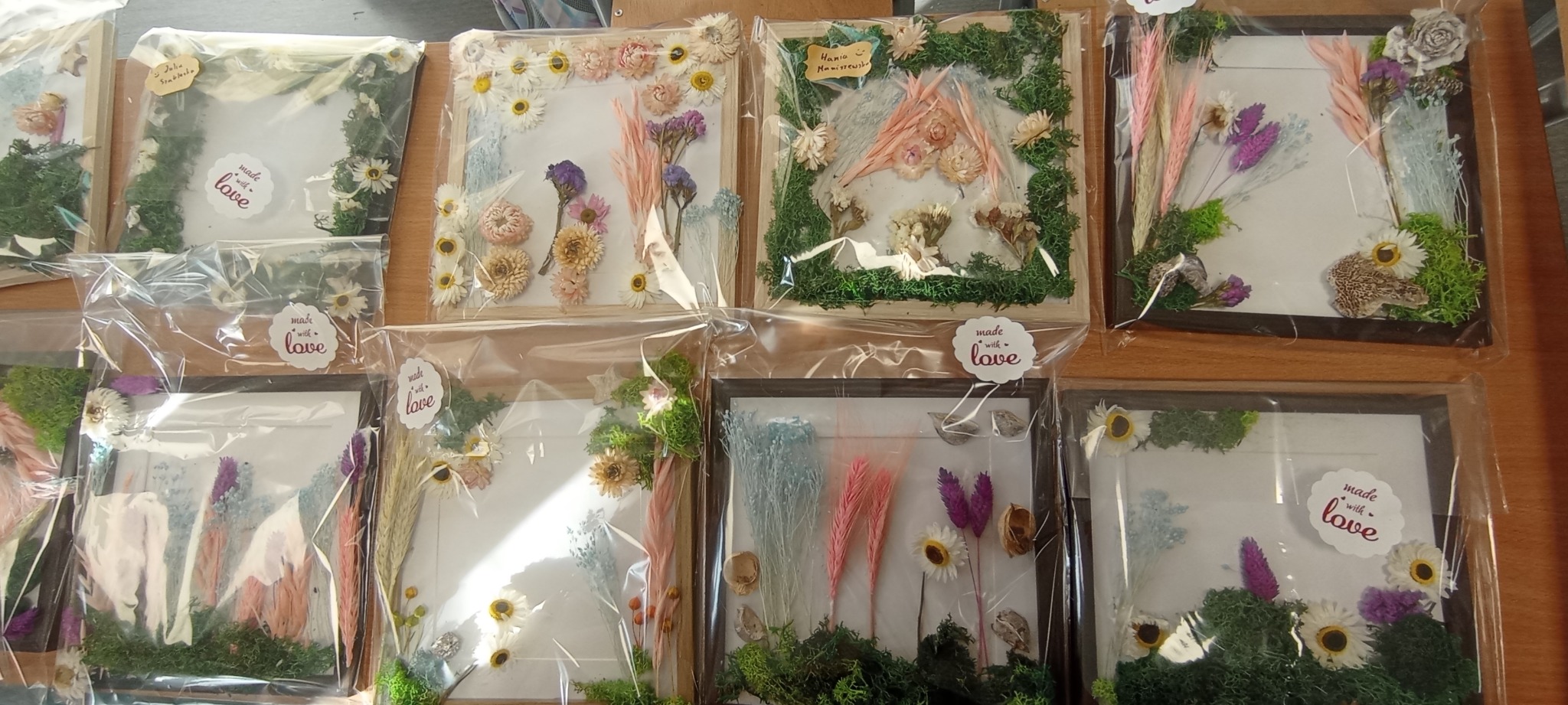 Ręcznie robione, unikalne kompozycje z suszonych kwiatów i mchu w ramkach, zapakowane w folię. Każda ramka ma inny układ i kolorystykę, z naklejką 'made with love'.