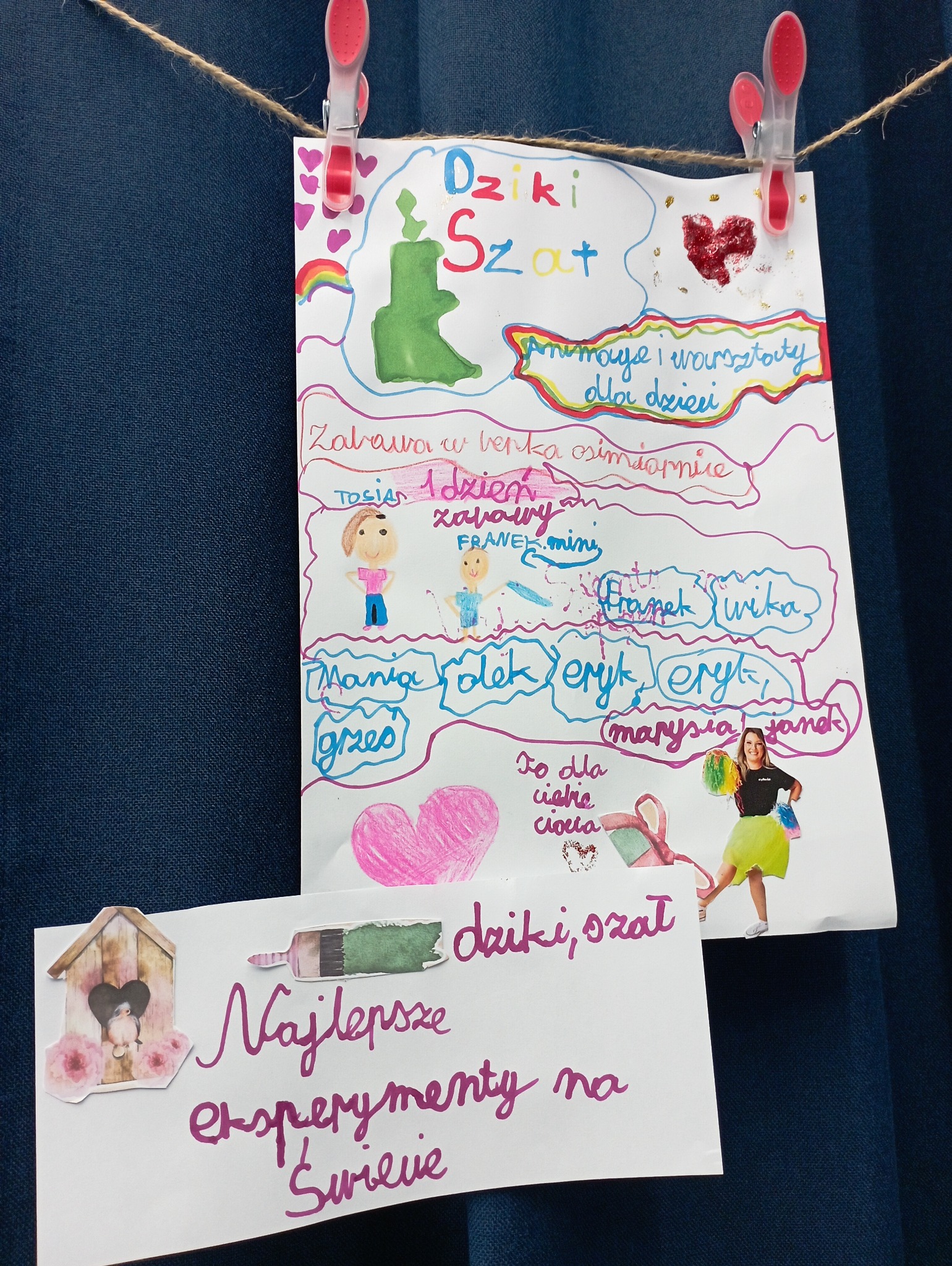 Ręcznie robione kartki z rysunkami dziecięcymi i napisami, zawieszone na sznurku za pomocą klamerek, prezentujące ofertę animacji i warsztatów dla dzieci.