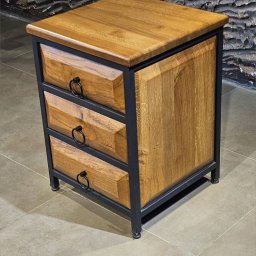 Mariusz isiu - Drewniana szafka nocna z trzema szufladami, w stylu industrialnym, z metalową ramą i okrągłymi uchwytami, na tle ściany z kamienia dekoracyjnego.