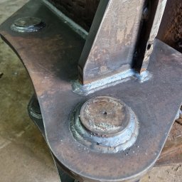 WELD IT-Mobilny Spawacz Ostrołęka - Spoina łącząca elementy metalowe, widoczne ślady spawania i obróbki. Detal konstrukcji stalowej po spawaniu, z bliska.