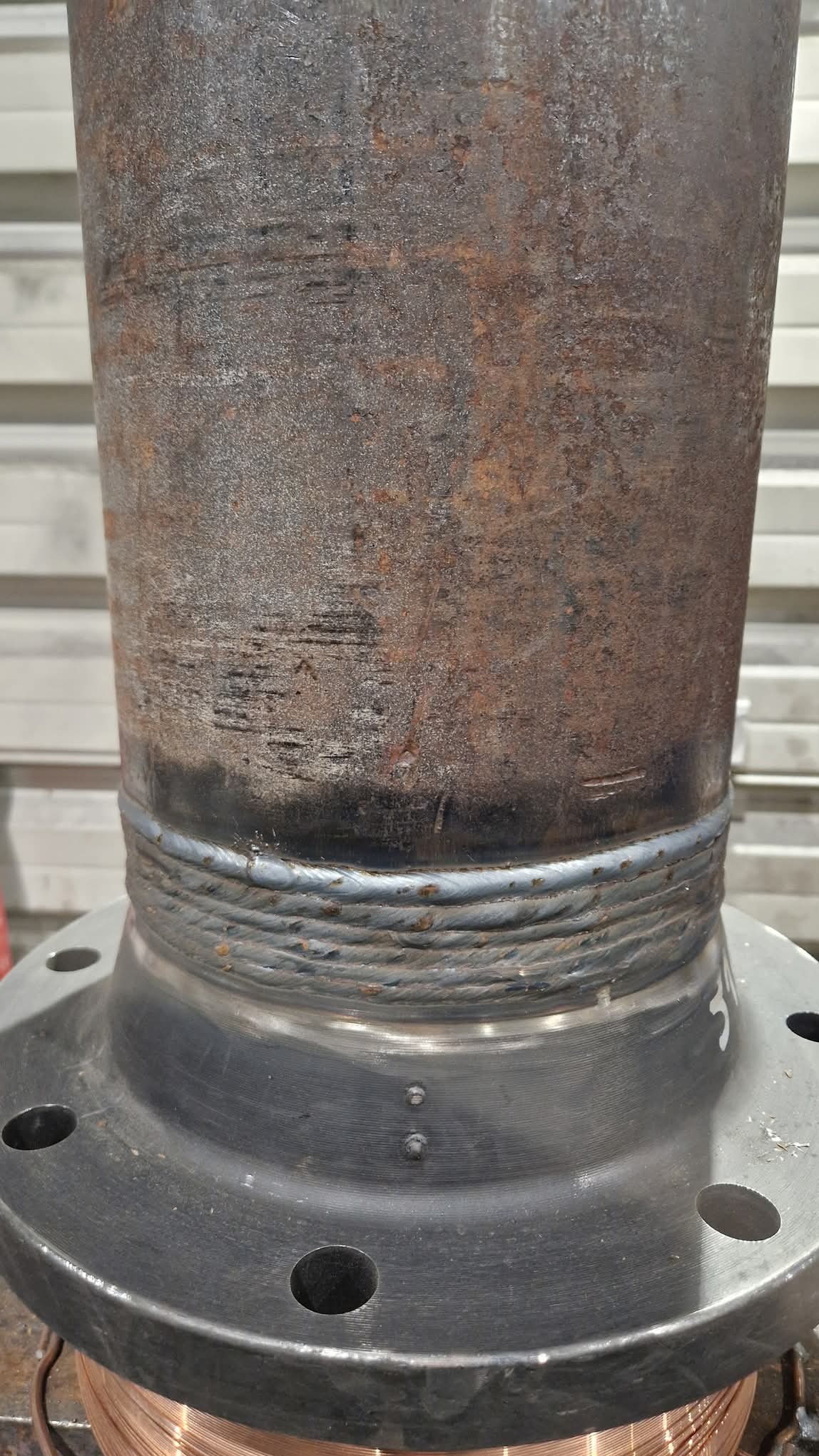 Spoina rury do flanszy, wykonana w Korczakach. Widoczne ślady rdzy na rurze i precyzyjne spawy. Detal złącza kołnierzowego.