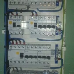 Farad Usługi Elektroinstalacyjne - Rozdzielnica elektryczna z zamontowanymi bezpiecznikami EATON i licznikiem Legrand, okablowanie w listwach. Widok z bliska na instalację w skrzynce.