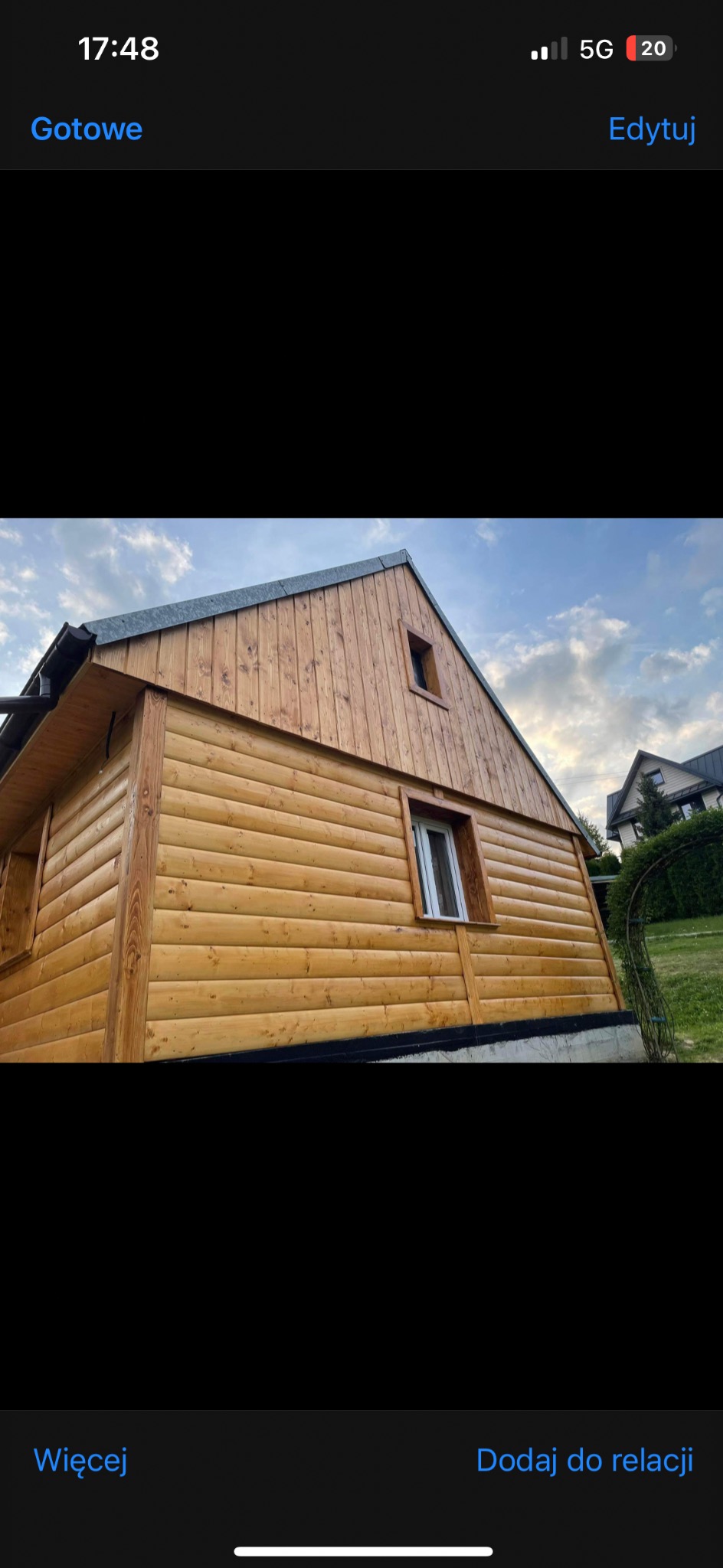 Drewniana elewacja domu z widocznymi oknami i fragmentem dachu. Ściany wykonane z jasnych, poziomych desek, tworzących ciepły i naturalny wygląd budynku.