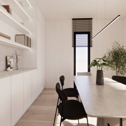 PROJEKTOWANIE WNĘTRZ Adrianna Lis - Minimalistyczna jadalnia: białe meble, drewniana podłoga, czarne krzesła i roślina w doniczce. Długi, wiszący żyrandol i okno z żaluzjami dodają nowoczesnego charakteru.