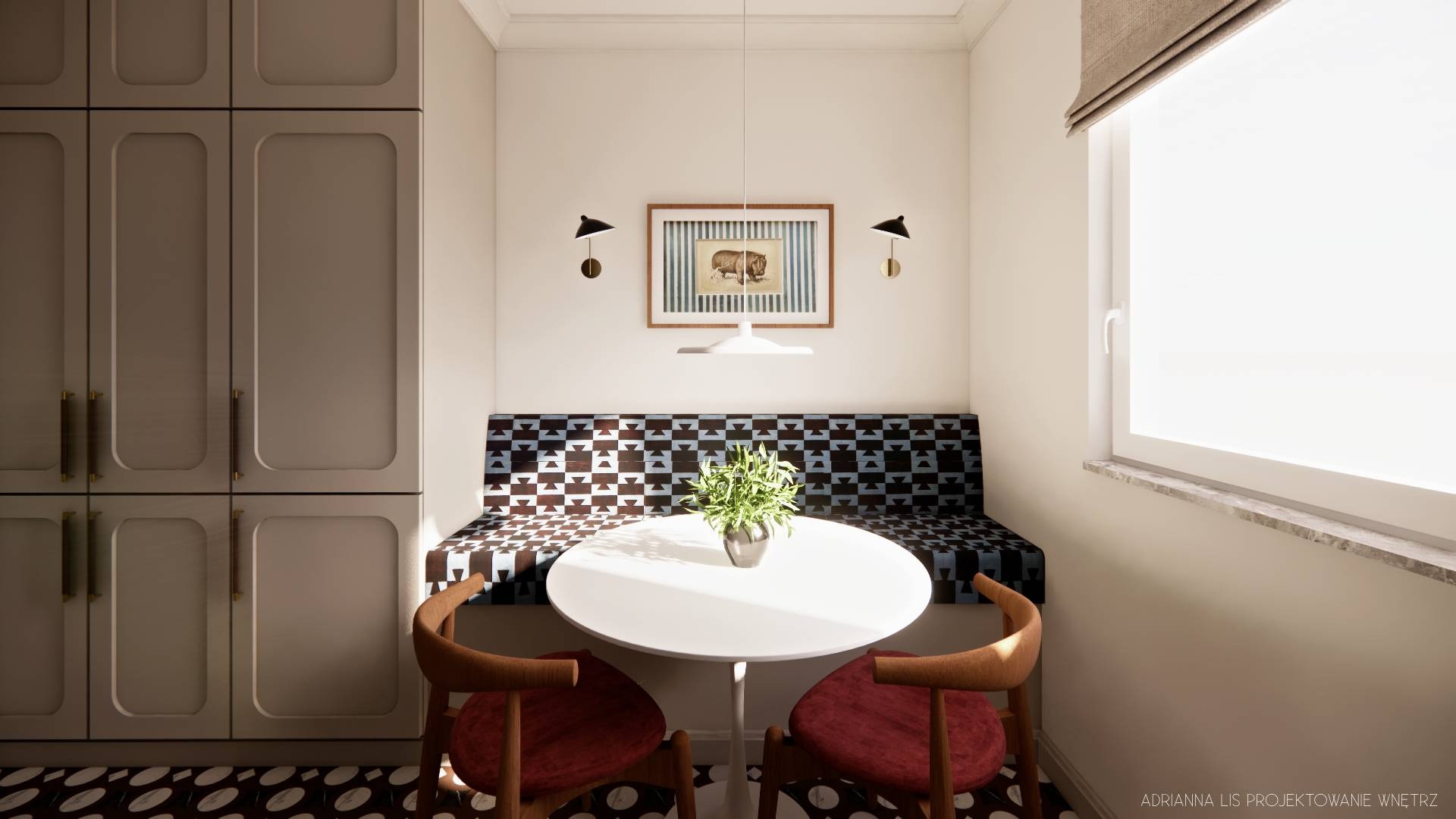 Kącik jadalny z zabudową kuchenną w odcieniach szarości, okrągłym stołem i wzorzystą tapicerką siedziska. Dwa krzesła z czerwonym obiciem. Całość doświetlona światłem dziennym.