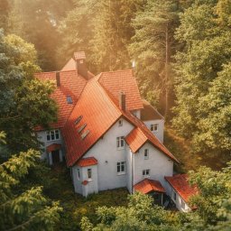 Prywatny Ośrodek Terapii Uzależnień Space Therapy Wielkopolska - Dwupiętrowy budynek z czerwonym dachem, otoczony zielenią, widziany z góry w Obrzycko. Ujęcie podkreśla naturalne otoczenie i architekturę budynku.