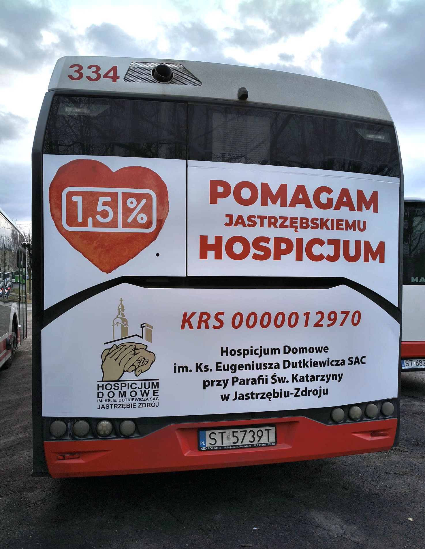 Autobus miejski z reklamą hospicjum: czerwone serce z 1,5%, napis 'Pomagam Jastrzębskiemu Hospicjum' i logo hospicjum. Tablica rejestracyjna ST 5739T.