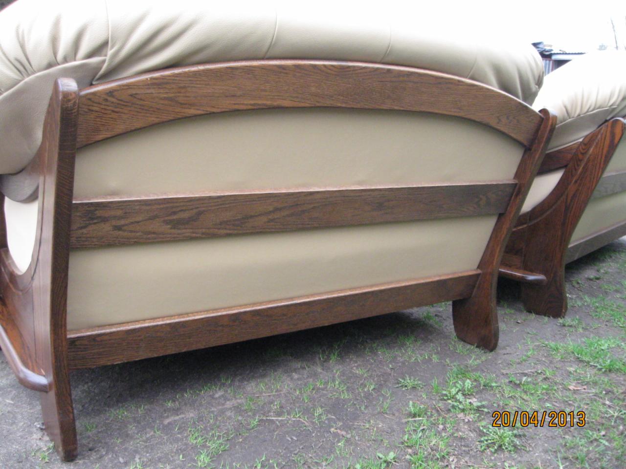 Fragment kompletu wypoczynkowego z dębowym stelażem, widok z tyłu ukazujący beżowe obicie i konstrukcję na tle trawy.