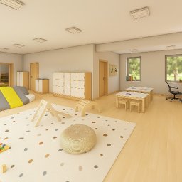 Aleksandra Nycz - Jasne wnętrze sali zabaw z drewnianymi meblami, kolorową podłogą w kropki i miękkimi elementami do wspinaczki. Widoczne stoliki, krzesła i szafki.