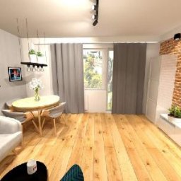 SolidHouse - Jasne wnętrze salonu z drewnianą podłogą, ceglaną ścianą i nowoczesnymi meblami. Widoczne obrazy na ścianie, okrągły stół i sofa. Styl loftowy z elementami dekoracyjnymi.