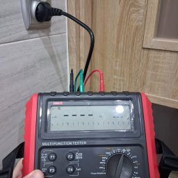 Arkadiusz Dziewiecki - Miernik wielofunkcyjny UNIT-T UT593 podłączony do gniazdka elektrycznego, z widocznymi przewodami pomiarowymi. Pomiar instalacji elektrycznej w trakcie realizacji.