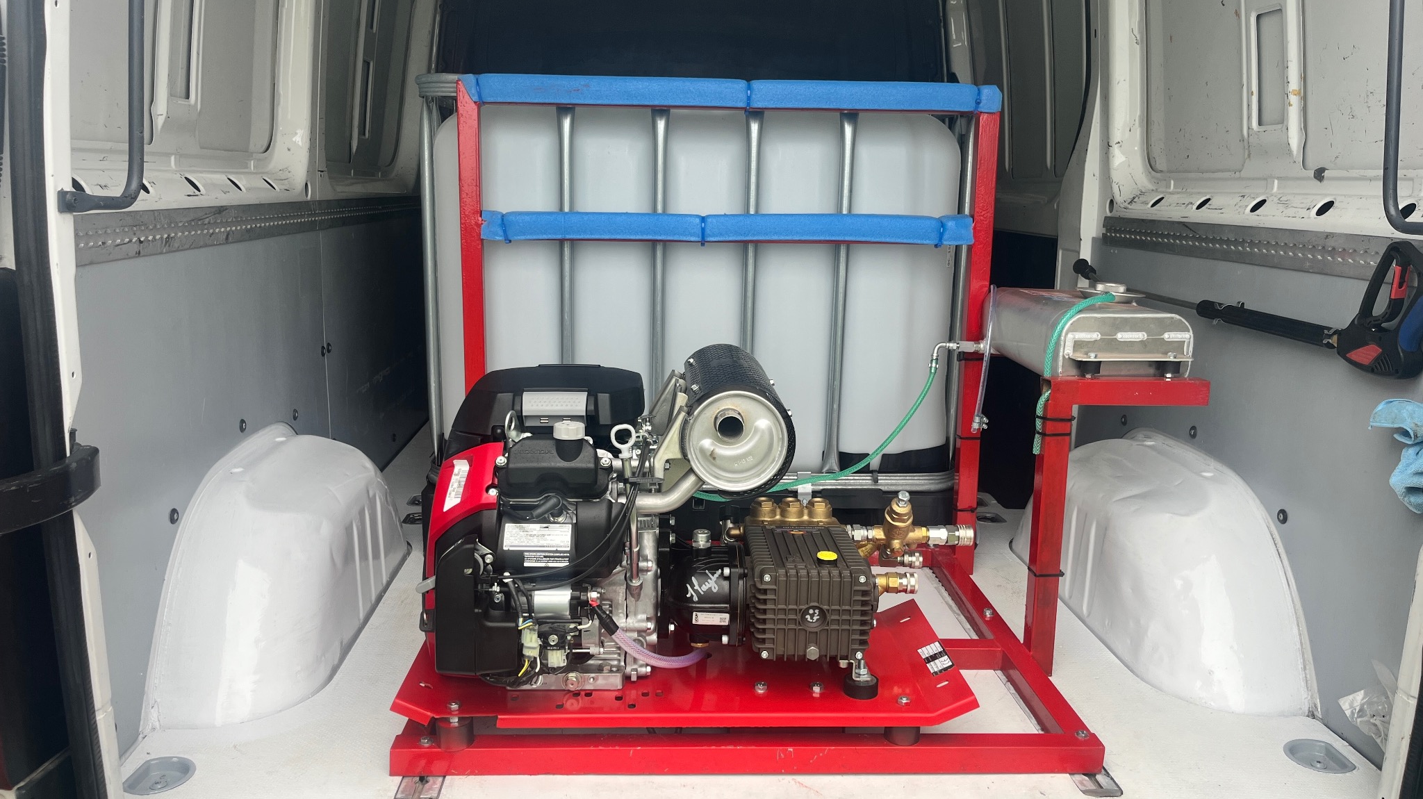 Mobilny zestaw do mycia ciśnieniowego w furgonetce: zbiornik na wodę, pompa spalinowa i lanca. Gotowy do pracy sprzęt do czyszczenia elewacji i kostki brukowej.