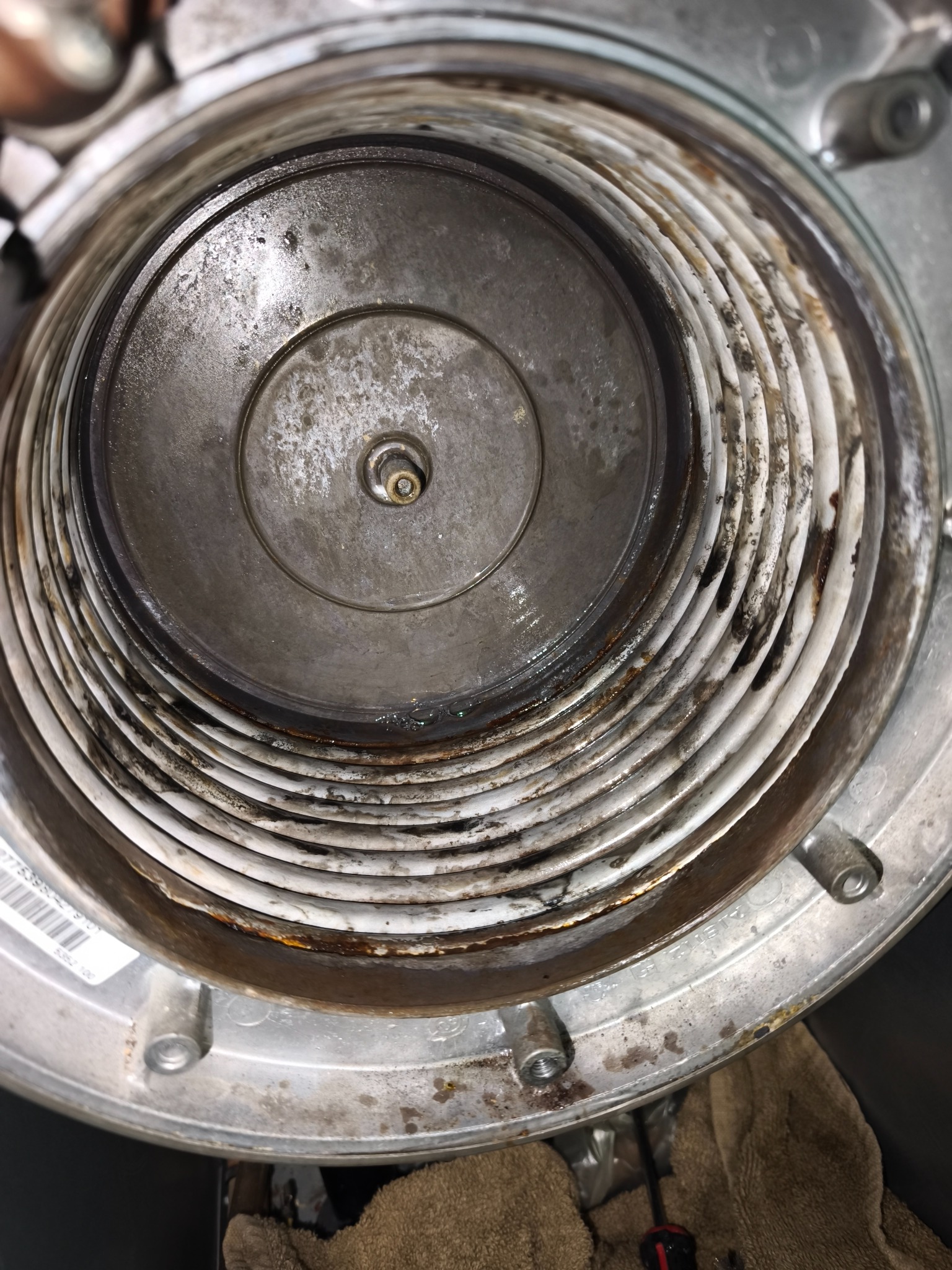 Wnętrze kotła gazowego z widocznymi elementami grzewczymi, wymagające serwisu w Oławie. Widoczne ślady korozji i zabrudzenia.