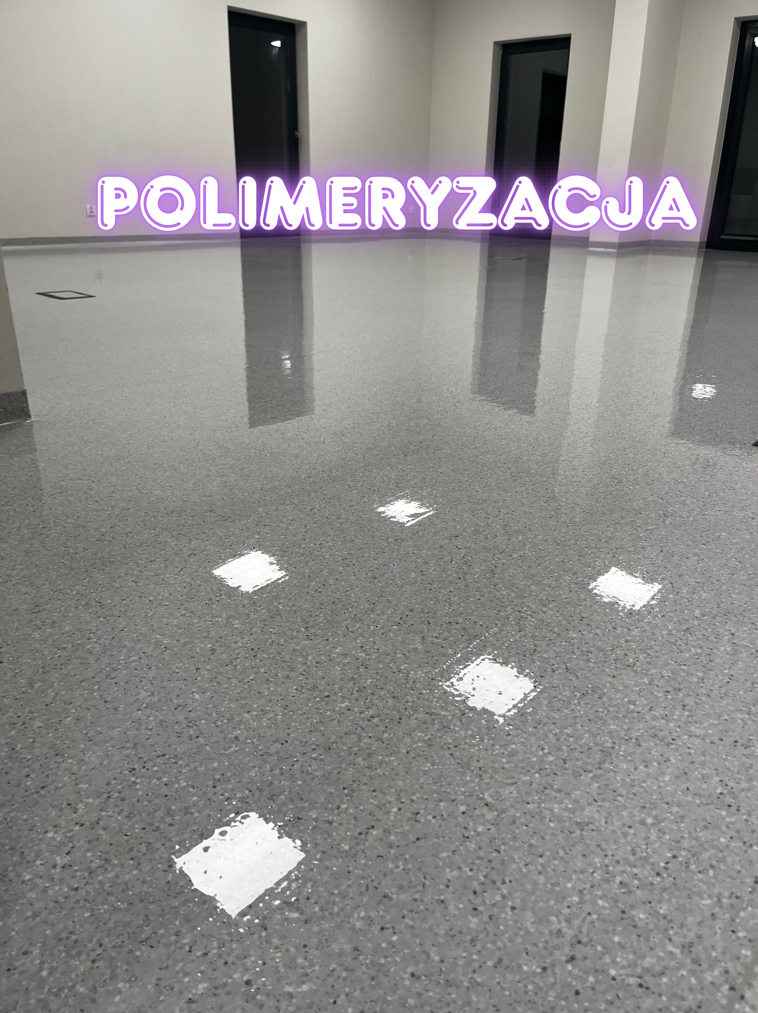 Błyszcząca, szara posadzka żywiczna z efektem lastryko w nowym biurze, odbijająca światło lamp i neonowy napis 'Polimeryzacja'. Widoczne dwie pary drzwi.