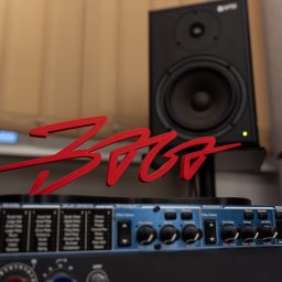 Miłosz Tuszyński - Baga Sound - Sprzęt studyjny: monitor odsłuchowy, procesor efektów i czerwone logo. Elementy wyposażenia studia nagrań w zbliżeniu, z widocznymi detalami.