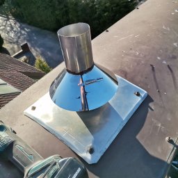 Łukasz Urbaniak - Metalowy wkład kominowy z narzędziem w tle, widok z góry. Usługa wykonana w Poznaniu. Błyszcząca powierzchnia odbija otoczenie.