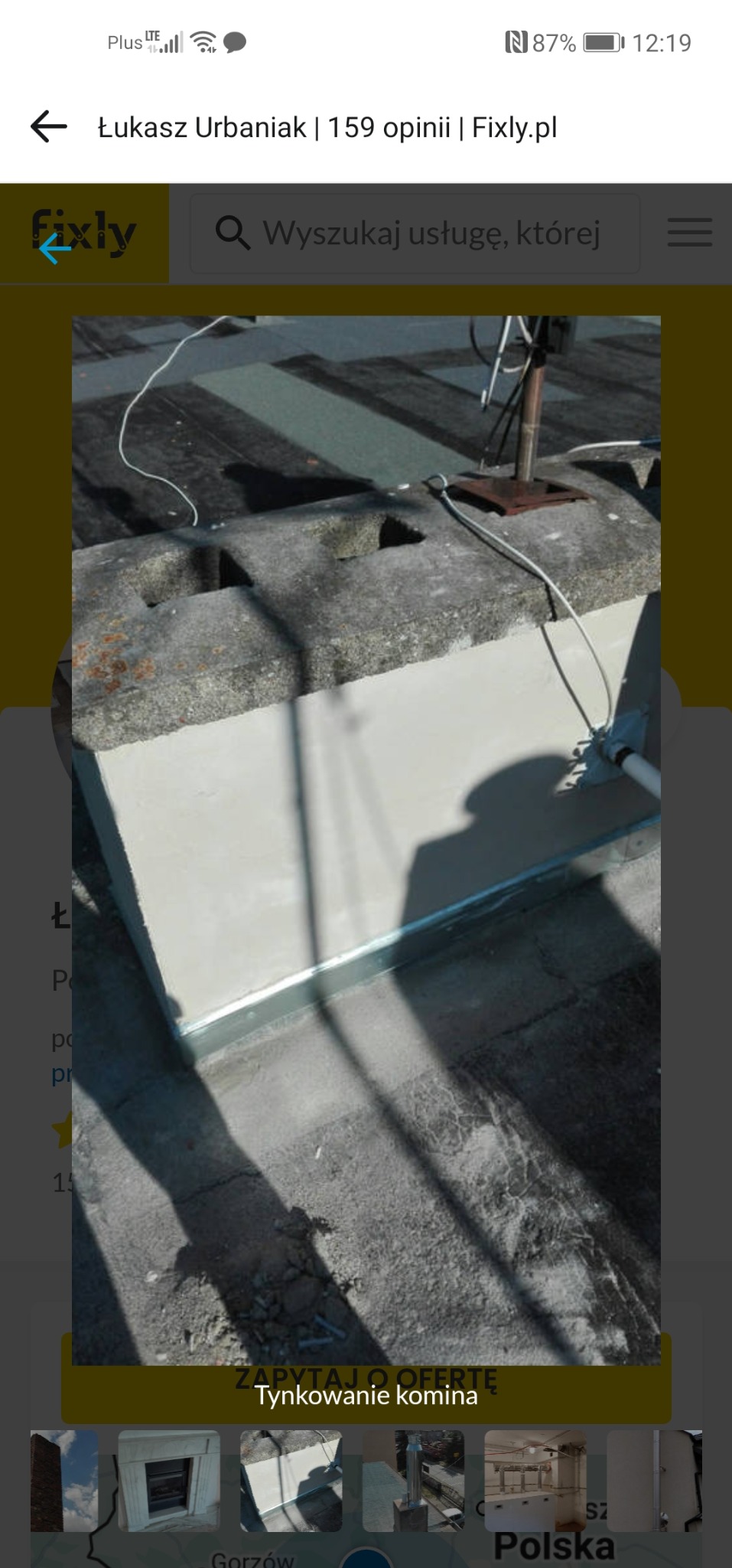 Otynkowany komin z metalowym obramowaniem na dachu, widoczne przewody i cień. Detal wykończenia komina po renowacji, z bliska.