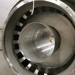 Weldingteam - Wnętrze konstrukcji ze stali nierdzewnej z perforowanymi elementami, widoczne spawane łączenia. Elementy cylindryczne wewnątrz większej obudowy.