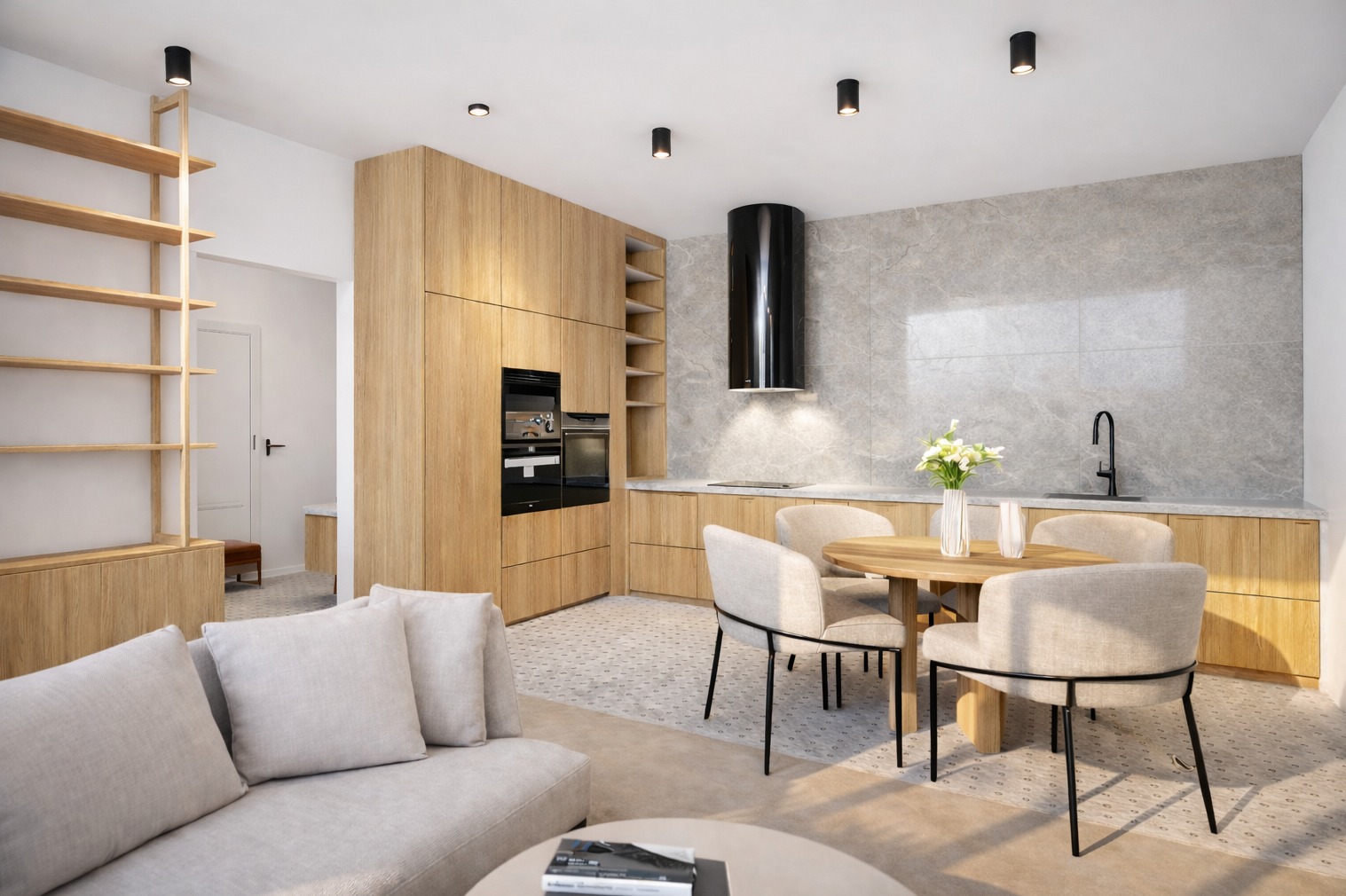 Jasna kuchnia z drewnianymi szafkami, czarnym okapem i okrągłym stołem jadalnym. W tle widoczny salon z beżową sofą i regałem. Całość w nowoczesnym stylu.