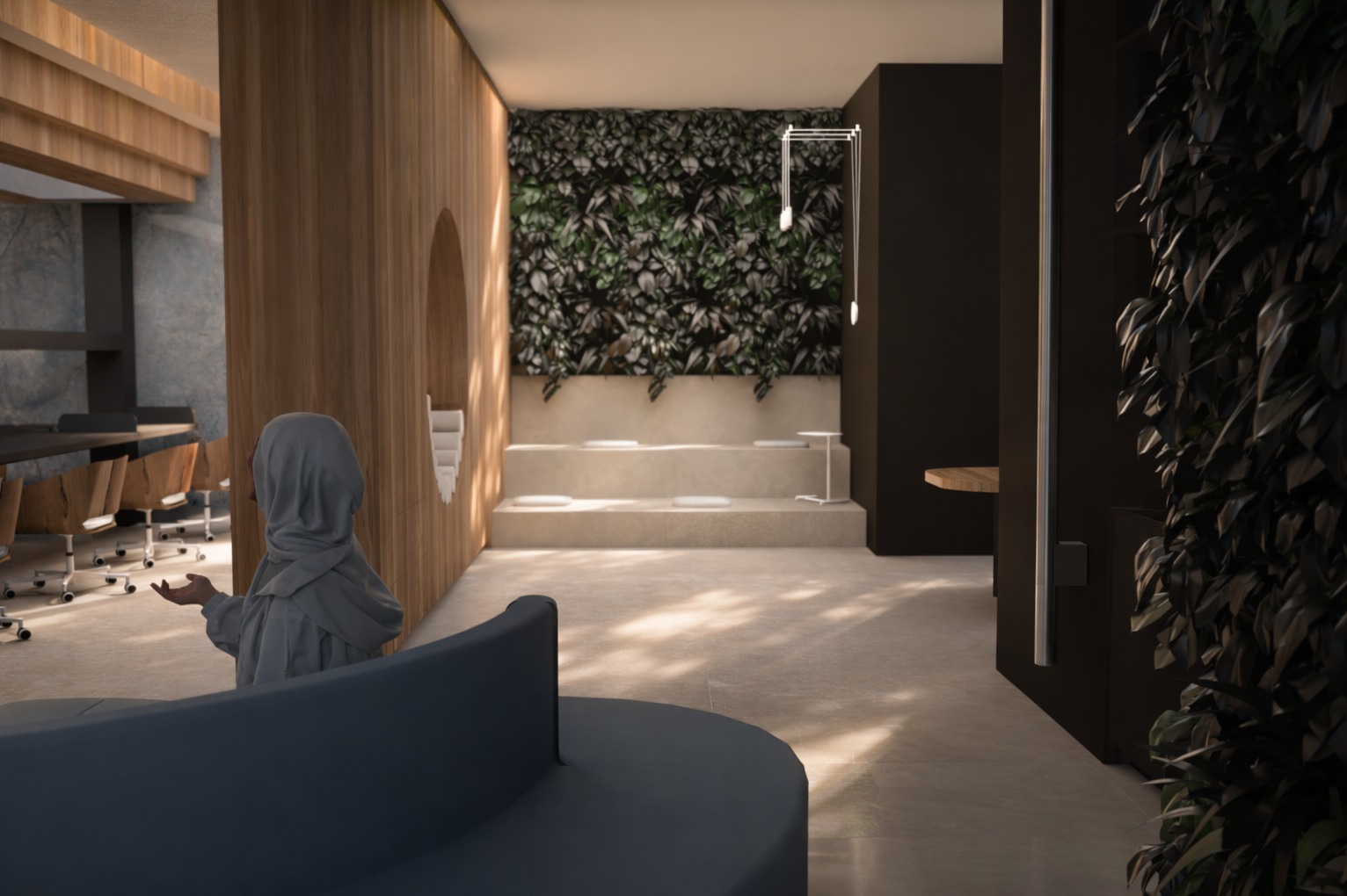 Nowoczesne biuro z drewnianymi elementami, zieloną ścianą i nietypową strefą relaksu z podestami i okrągłą sofą. Osoba w szarym stroju w tle dodaje skali.