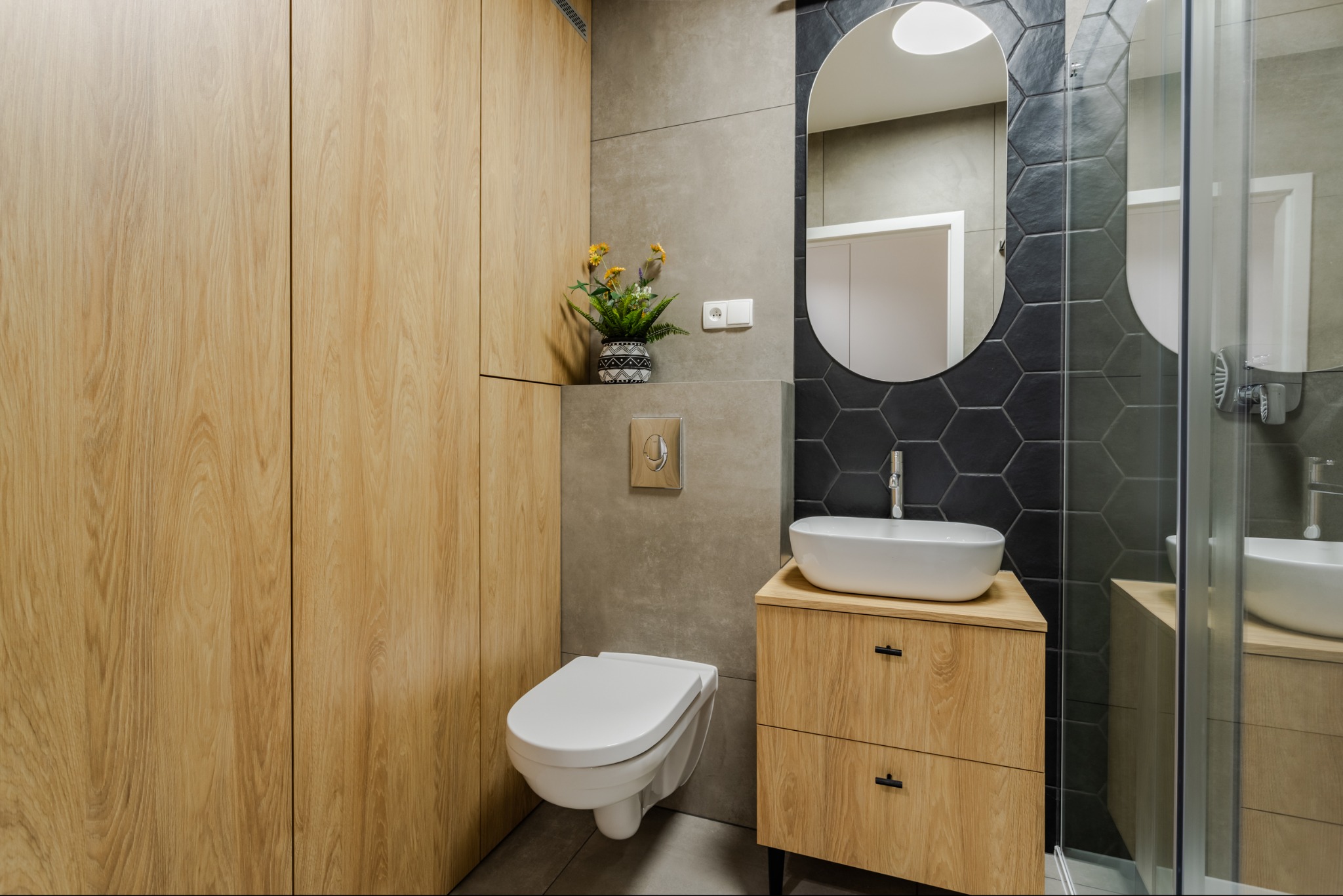 Pralka została dyskretnie ukryta w zabudowie meblowej, dzięki czemu wnętrze zachowuje spójny i uporządkowany charakter.