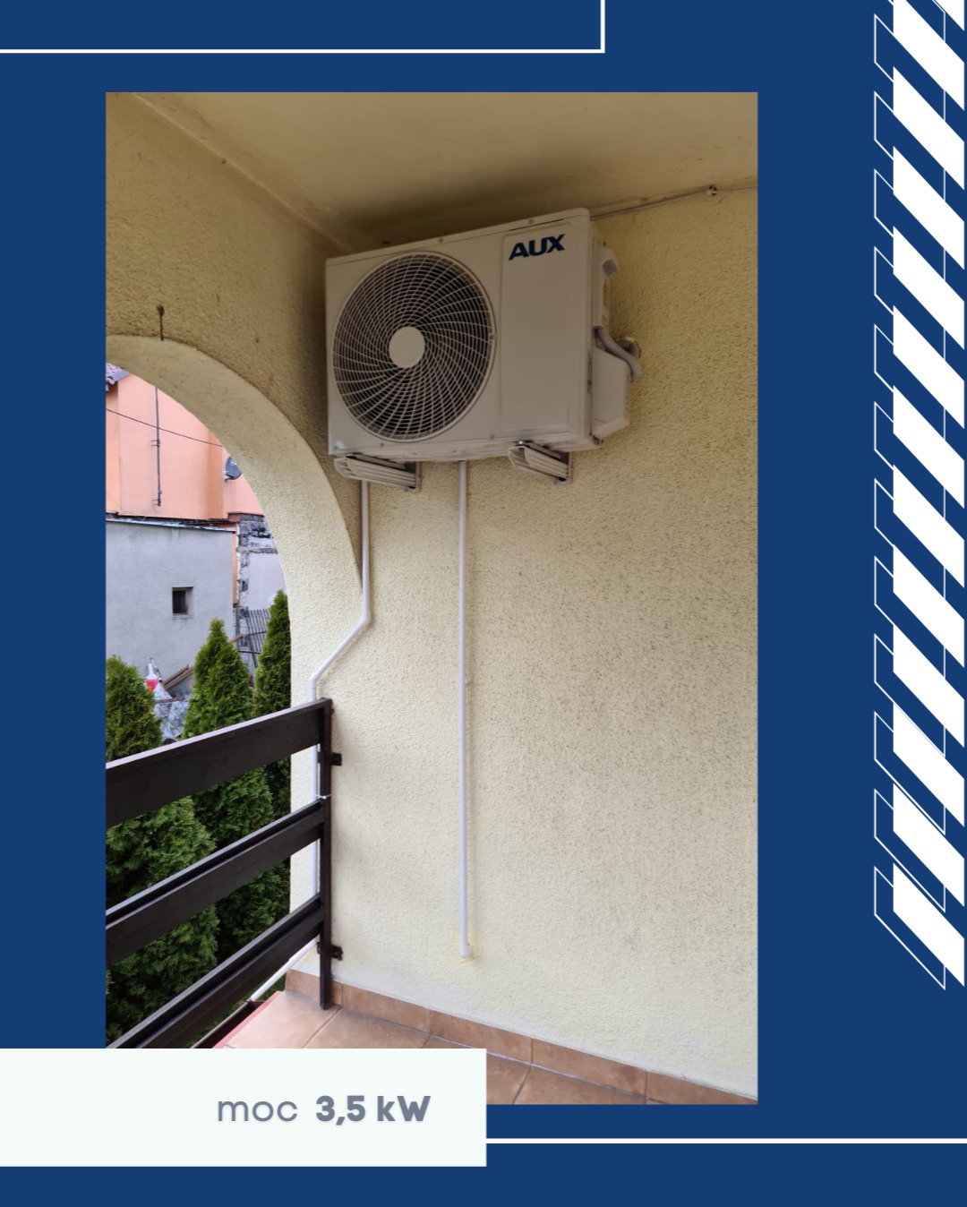 Biała jednostka zewnętrzna klimatyzacji AUX 3,5 kW zamontowana na balkonie z beżową ścianą, widok z dołu, z fragmentem balustrady i zieleni w tle.