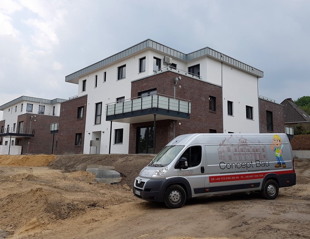 Nowoczesny budynek wielorodzinny z elementami cegły klinkierowej i balkonami, na pierwszym planie srebrny bus firmy budowlanej z widocznym logo.
