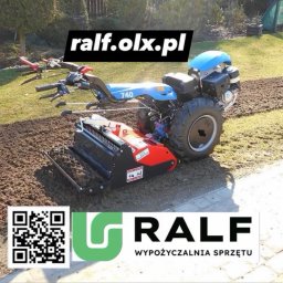 RALF Wypozyczalnia Sprzętu oraz Usługi - Niebieski glebogryz z czerwonym elementem roboczym na trawniku z przygotowaną glebą. Widoczne ślady pracy maszyny.